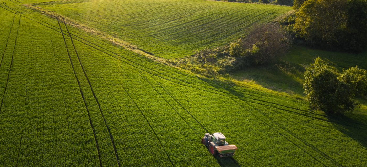 A farmer tills a field with his tractor